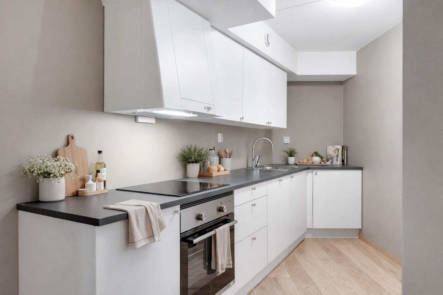 Moderne og stilrent kjøkken med lyse fronter og god benkeplass. Praktisk utforming gir effektive arbeidsflater og gode oppbevaringsmuligheter.